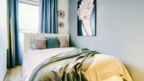 Serene, light-filled bedroom with plush bed, soft linens, and chic décor.