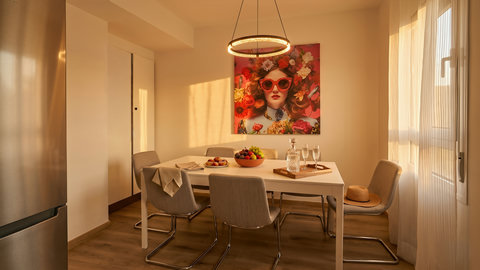 Sunlit dining nook with modern flair, pendant light, and cozy seating