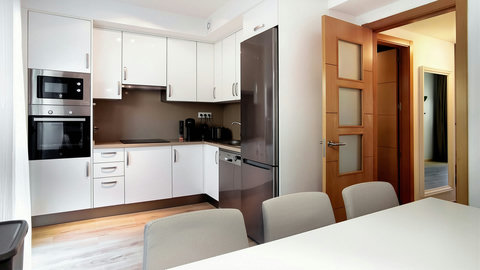Sleek, fully equipped kitchen with dining nook and stainless appliances