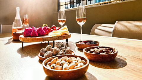 Sunlit patio with rosé, cheese board and gourmet nibbles for alfresco lounging
