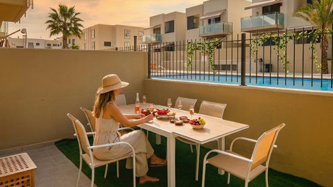Private patio dining with pool views—sunset-ready oasis in a modern complex.