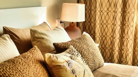 Cozy layered bed with warm lighting and textured neutral accents
