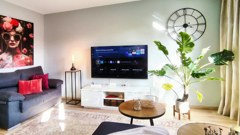 Bright modern lounge with smart TV, chic decor, and cozy seating.
