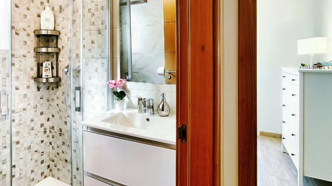 Bright modern bath with glass shower; steps from sleek bedroom