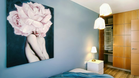 Serene blue bedroom with statement art, warm lighting, and ample wardrobe