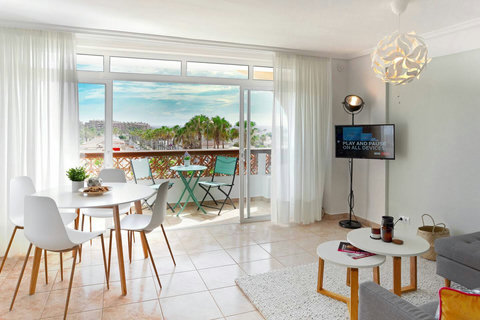 Bright living space with balcony dining and lovely palm-view terrace