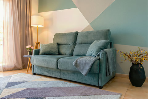 Cozy, light-filled lounge with plush sofa and chic geometric accents