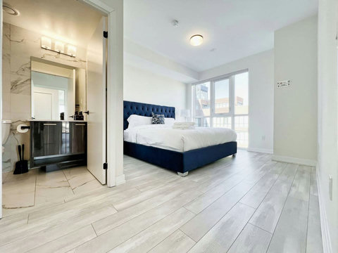 Relax in this cozy bedroom featuring plush bedding and calming decor