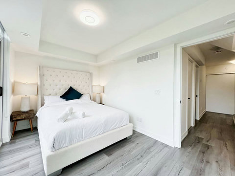 Well-equipped bedroom featuring a neatly lit towel shelf for added comfort.