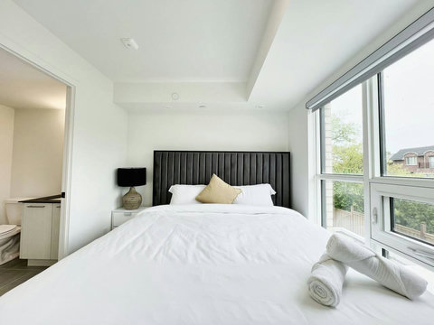 Well-equipped bedroom featuring a neatly lit towel shelf for added comfort.