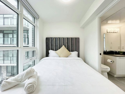 Well-equipped bedroom featuring a neatly lit towel shelf for added comfort.
