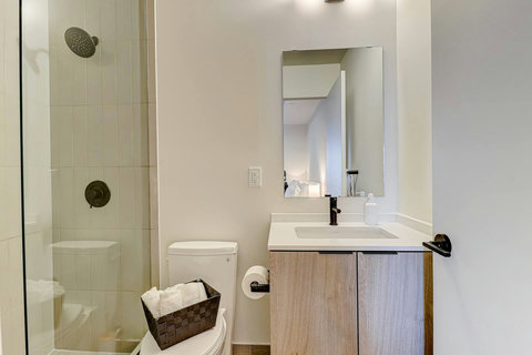 Modern bathroom with fresh towels and essential toiletries provided.