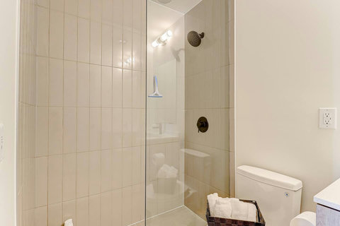 Modern bathroom with fresh towels and essential toiletries provided.