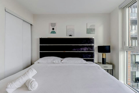 Bright and cozy bedroom featuring a comfortable king bed, fresh linens, and a peaceful ambiance for deep relaxation.