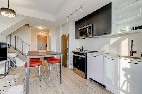 Modern full kitchen with stainless-steel appliances, coffee machine, dishwasher, and all essentials for home-style cooking. Perfect for preparing meals and enjoying family dinners together.