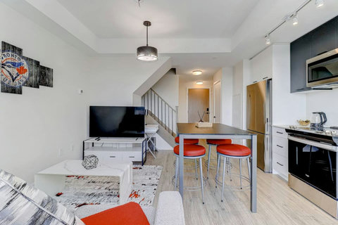 A bright, modern living room with cozy seating, smart TV, and elegant décor—perfect for relaxing after a day exploring Toronto. The sofa easily converts into a comfortable bed for extra guests.