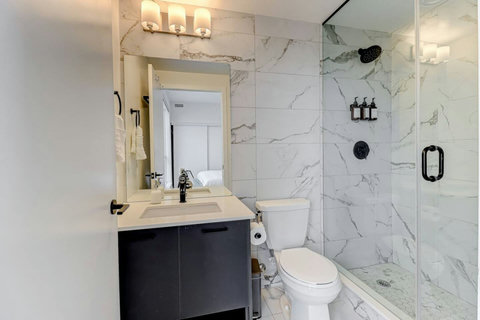 Bright full bathroom featuring a sleek vanity, spacious shower, and premium essentials—designed for comfort and relaxation.