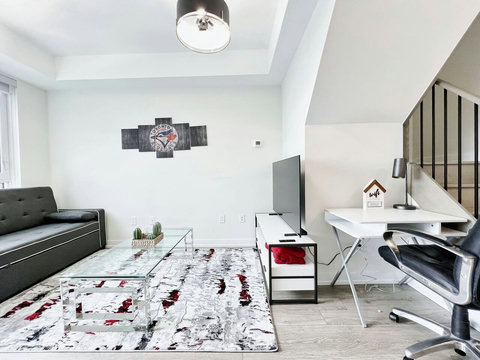 A bright, modern living room with cozy seating, smart TV, and elegant décor—perfect for relaxing after a day exploring Toronto. The sofa easily converts into a comfortable bed for extra guests.