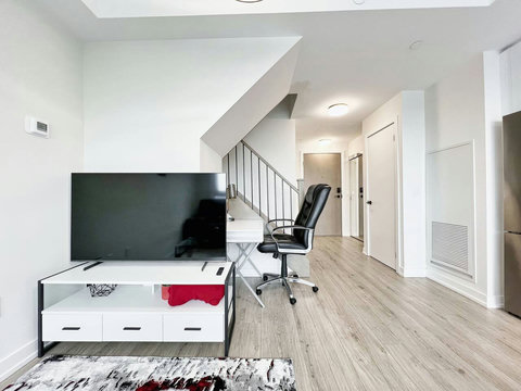 A bright, modern living room with cozy seating, smart TV, and elegant décor—perfect for relaxing after a day exploring Toronto. The sofa easily converts into a comfortable bed for extra guests.