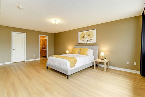 Wrap yourself in comfort and style with this bedroom’s plush bedding and inviting warm accents