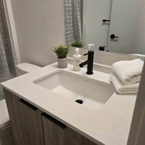 Spotless, modern bathroom with fresh towels and essentials.”