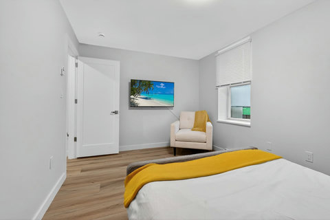 Spacious ensuite room with a soft queen bed and clean, modern design.