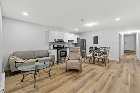 Open-concept living room with stylish seating, dining area, and seamless kitchen connection