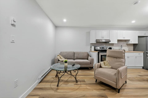 Warm and inviting living room equipped with a sofa, TV, dining table, and open kitchen layout