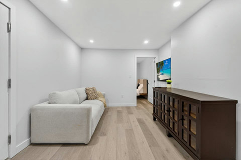 Well-furnished living room featuring a cozy sofa, modern TV, and a complete setup for comfort.