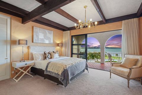 The best bedroom in the house with first-floor views through a ranch slider onto a covered verandah with Spanish arches.