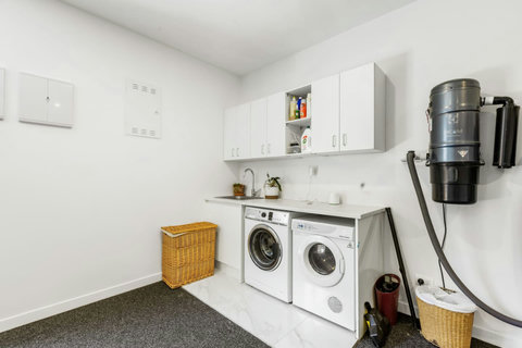 The laundry has a front-loading washing machine and dryer.