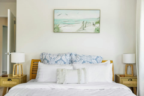 The main bedroom has a king-sized bed with lovely blue and white cushions and throws to create a calm and restful environment.