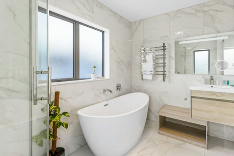 The ensuite bathroom also has a shower, toilet, vanity unit, and awesome bathtub.