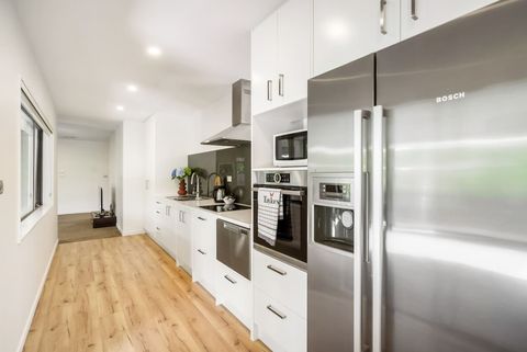 The kitchen has a double door fridge/freezer, dish drawer, oven, microwave, cooktop and range hood.