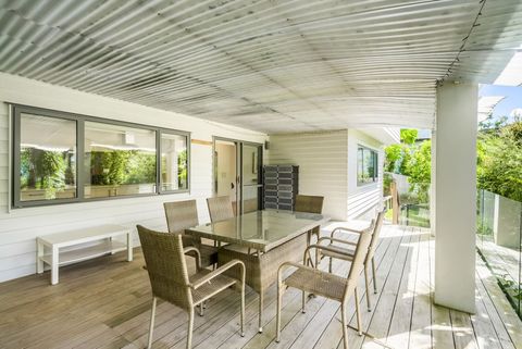 The covered patio has a dining suite, two ranch slider doors, and access to the garden.