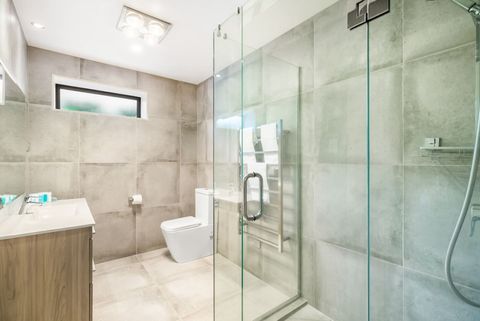 The bathroom has a shower, vanity and toilet.