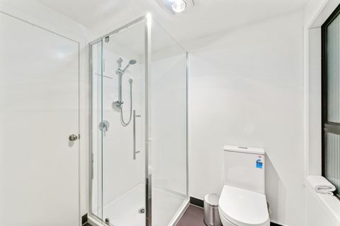 The bathroom has a shower, vanity and toilet.