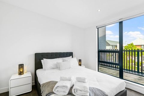 The bedroom has lots of natural light flooding through the large windows.
