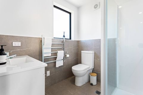 The bathroom has a shower, toilet, vanity, and heated towel rail.