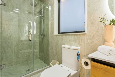 This bathroom has a full shower, toilet, and vanity with bathroom.