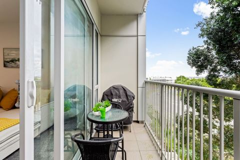Covered balcony with weber BBQ and seating area.