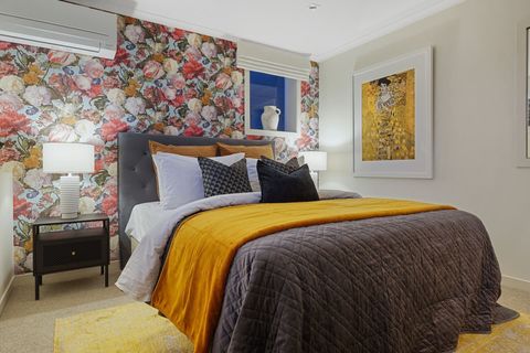The lovely gold tones in this bedroom flows from the throw, cushions, mat, wallpaper and the Klimpt Print of the "Lady in Gold", the portrait of  Adele Bloc-Bauer.