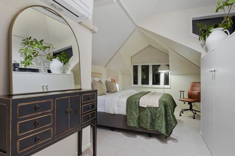 The mirror reflects the light and the greenery from the plant, adding warmth to the room.