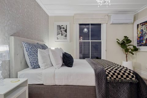This bedroom 2 invites you into the space with its chandelier, checkered throw and quirky artwork.