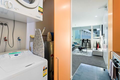 Behind the doors in the kitchen is the hidden laundry facilities of a washing machine and dryer.