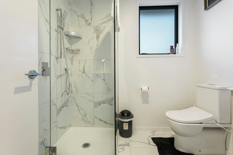 The bathroom has a toilet, shower, and vanity unit.