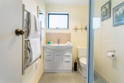 The bathroom features a modern shower, toilet, and vanity unit.