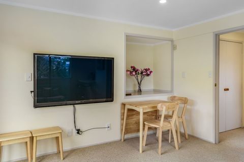 Relax on the couch and watch the large screen TV which is mounted to the wall.