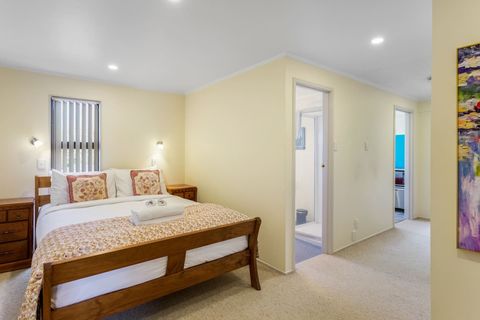 The apartment features a spacious bedroom with a Queen bed that has easy access to the bathroom and kitchen, with a door at the end of the hallway.