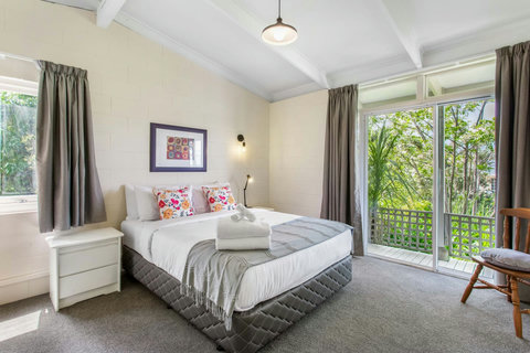 Queen bedroom bathed in natural light and access to the deck area.